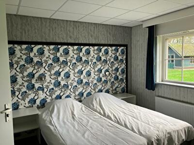 Twin kamer bedden blauwe bloemenwand